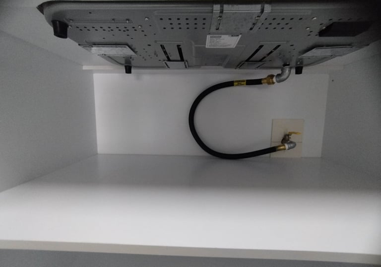 A black flexible gas pipe connecting home appliance with main gas line