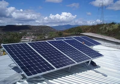 Photovoltaic solar panels installed on a residential metal roof for renewable energy.