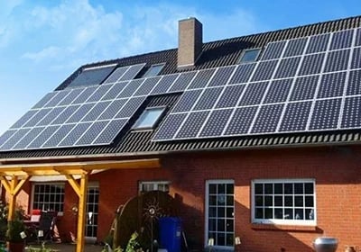 Residential brick house with rooftop solar panels installed for renewable energy efficiency.