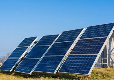 Ground-mounted solar panels harvesting renewable energy under a clear blue sky.