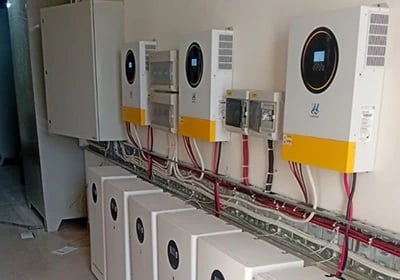 Multiple solar hybrid inverters and lithium battery storage units installed in a commercial power room.