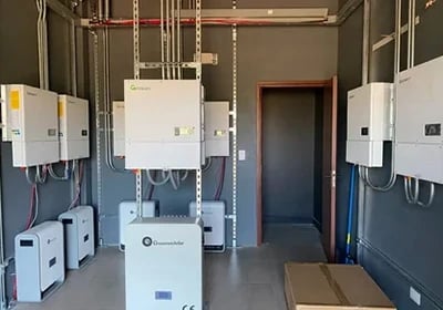 Professional solar power installation featuring multiple hybrid inverters and lithium battery storage units.