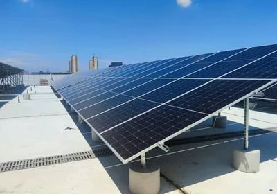 A commercial rooftop solar panel installation under a clear blue sky providing renewable energy.