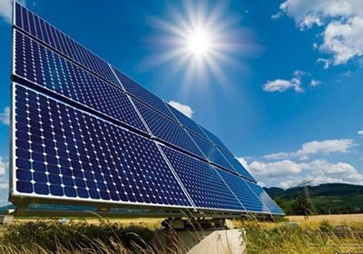 Photovoltaic solar panels harvesting renewable energy under a bright sun and blue sky.