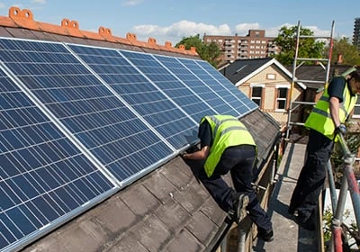 Professional contractors installing solar panels on a residential rooftop for renewable energy.
