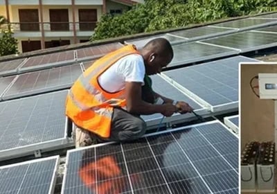 A technician installing solar panels on a roof with an inset of solar batteries and an inverter.