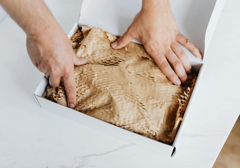 Hands carefully packaging handmade goat milk soap in eco-friendly wrapping paper for shipping