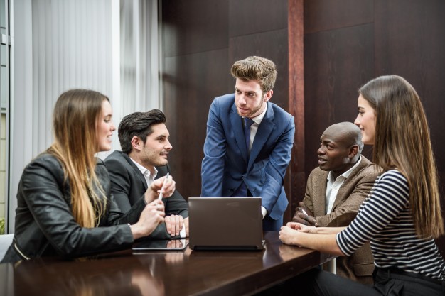 A diverse team of professionals collaborates during a corporate leadership training session.