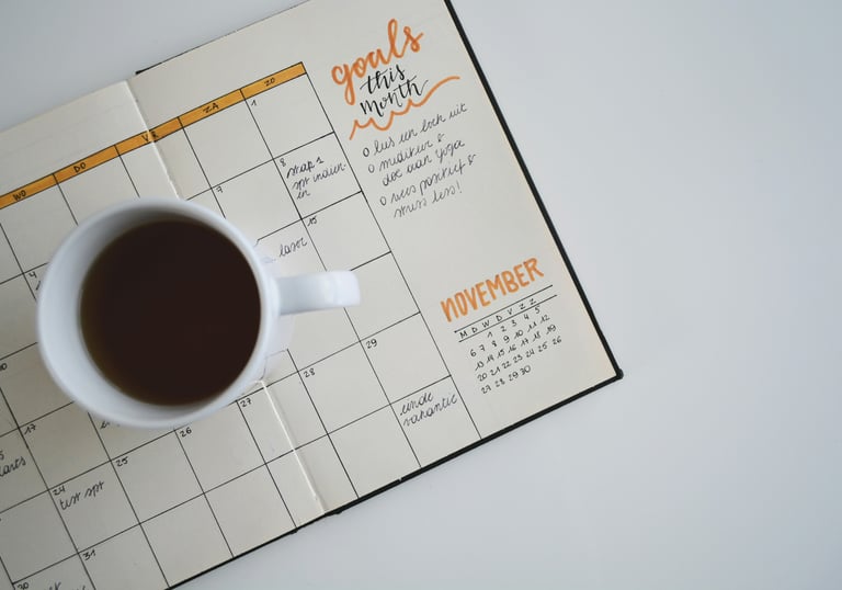 Mug with coffee on top of a calendar