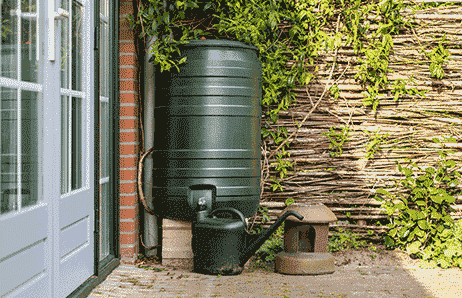 a large black water tank sitting in front of a house