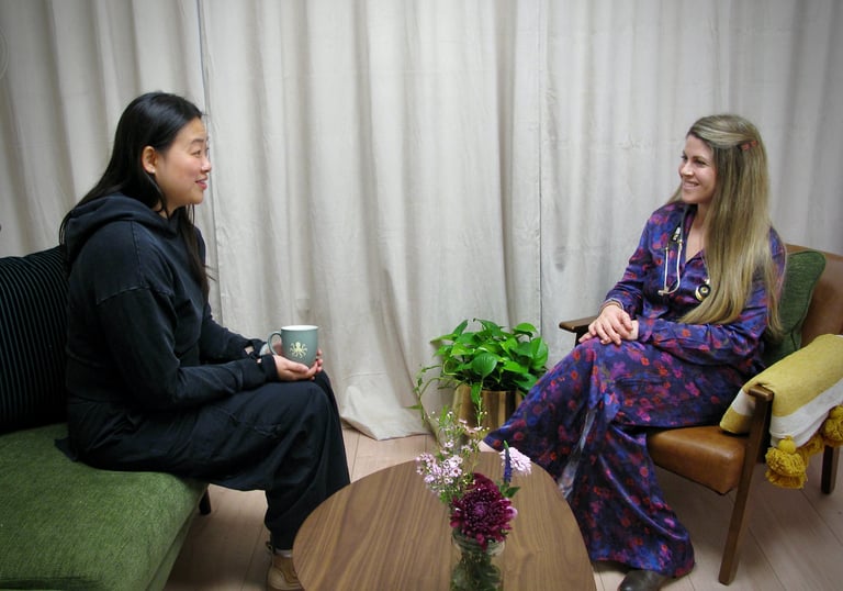 A healthcare professional and patient having a supportive consultation in a comfortable clinic setting.