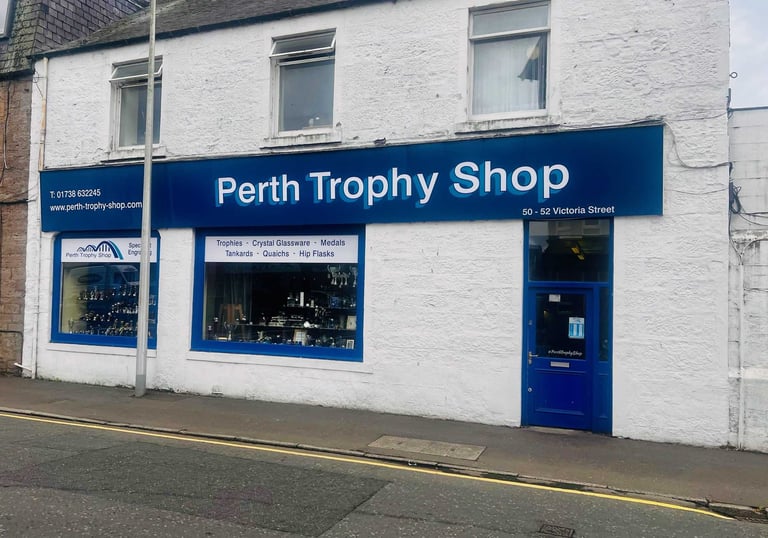 front of Perth trophy Shop with a blue sign