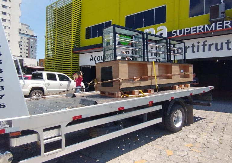 guincho carregando um balcão de madeira e vidro