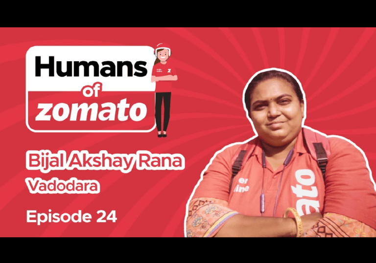 a woman in a red shirt in front of a banner called Humans of Zomato featuring Bijal Akshay Rana