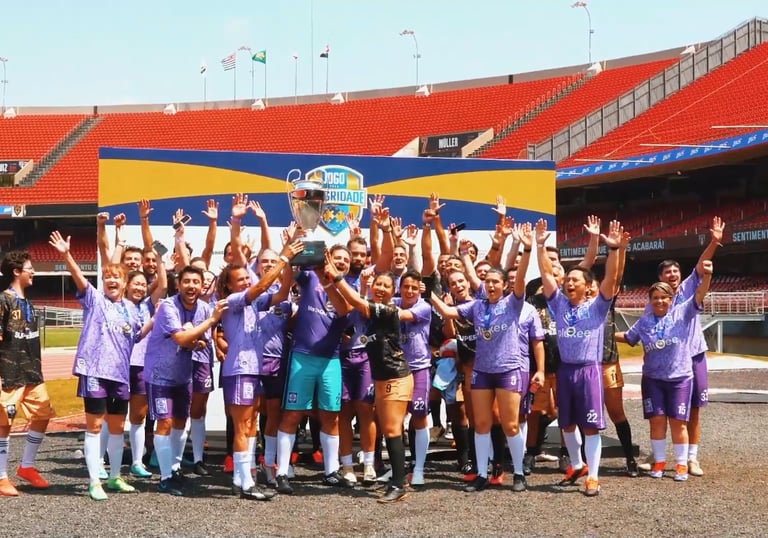 Time comemorando a vitória e carregando um troféu