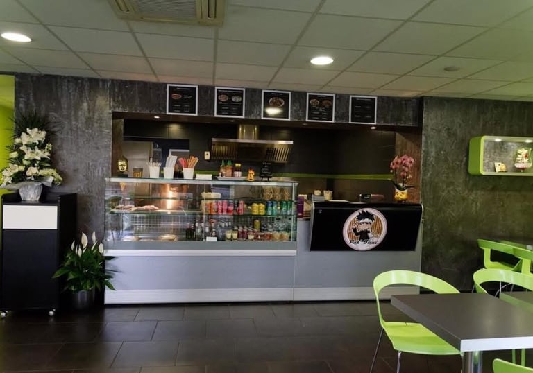 a restaurant with a counter top and a table with chairs