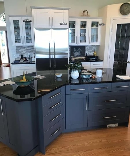 Two-tone kitchen with white shaker cabinets and a dark grey island.