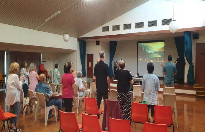 a group of people standing in front of a screen to worship