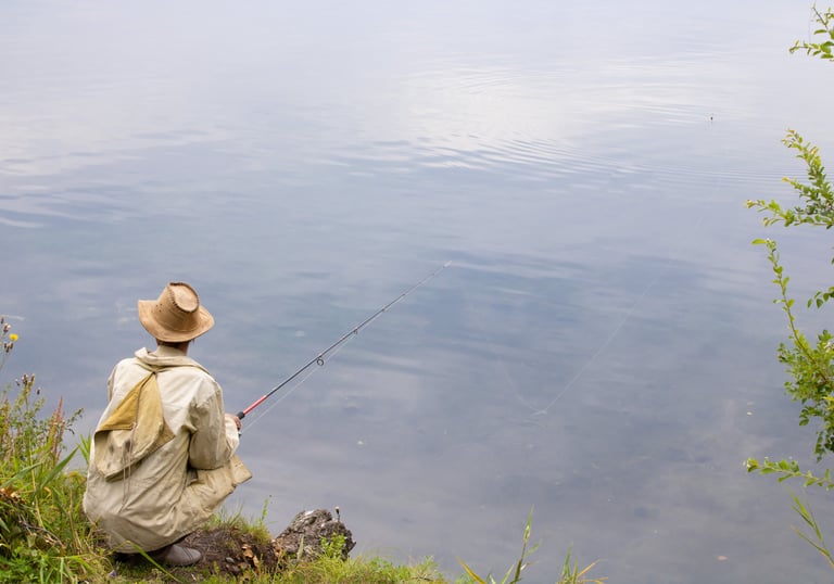Fisherman sitting on shore