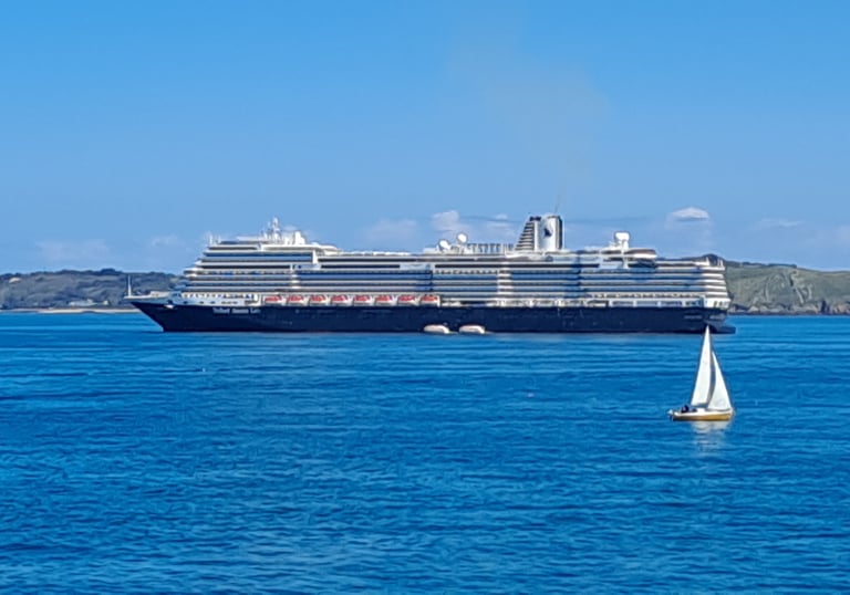 Sail boat on the sea with a cruise ship in the background