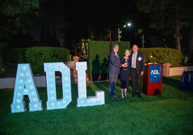 a man and woman standing in front large marque letters