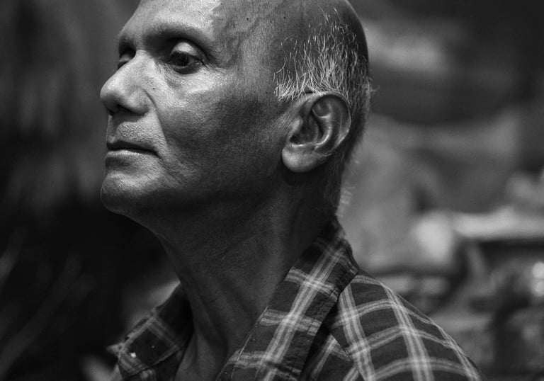 Black and white portrait of an elderly man with a calm expression, wearing a checkered shirt, taken in Mauritius