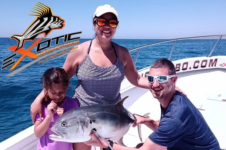 a woman , a man and a girl holding a fish caught on a boat at San Jose del cabo marina.