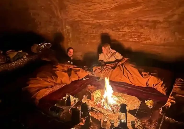 a man and woman sitting in a cave like setting