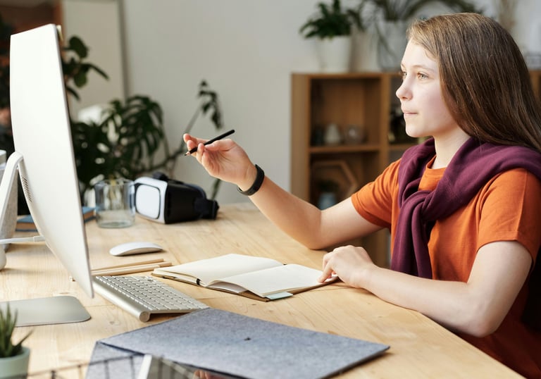 a student sitting at a table with a computer during online tuition