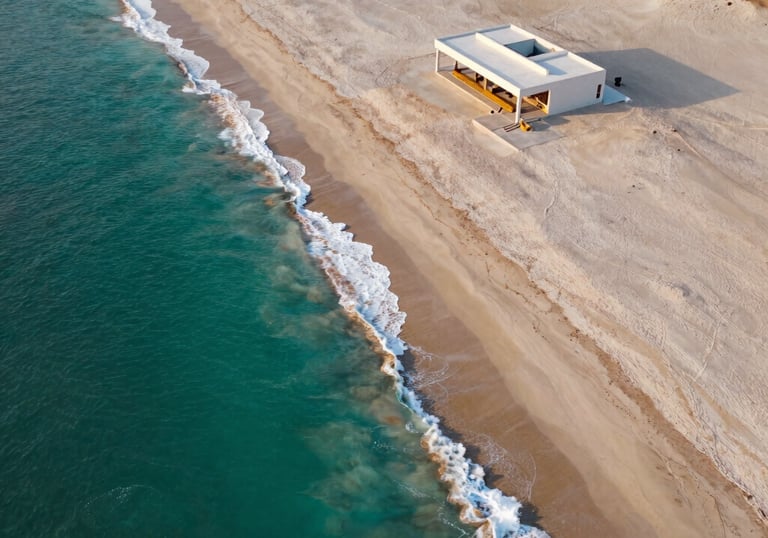 Aerial view of a pristine luxury beach property on the northern coast of Peru. Turquoise water, ivory sand, minimalist architectural structure, high contrast sunset lighting.