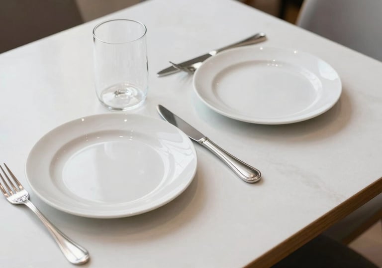 An overhead shot of a clean, minimalist restaurant table for two. No clutter, just high-quality porcelain and silver cutlery. The lighting is bright and airy, suggesting transparency and honesty. Western European / Dutch style.
