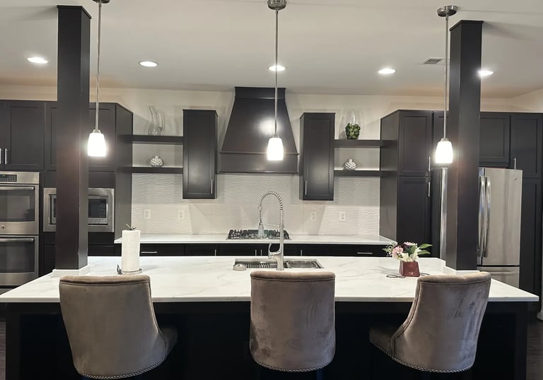 Modern kitchen with brown-veined quartz island and white 3D wave backsplash.