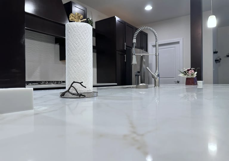 Close up of polished quartz countertop surface showing brown veining detail.