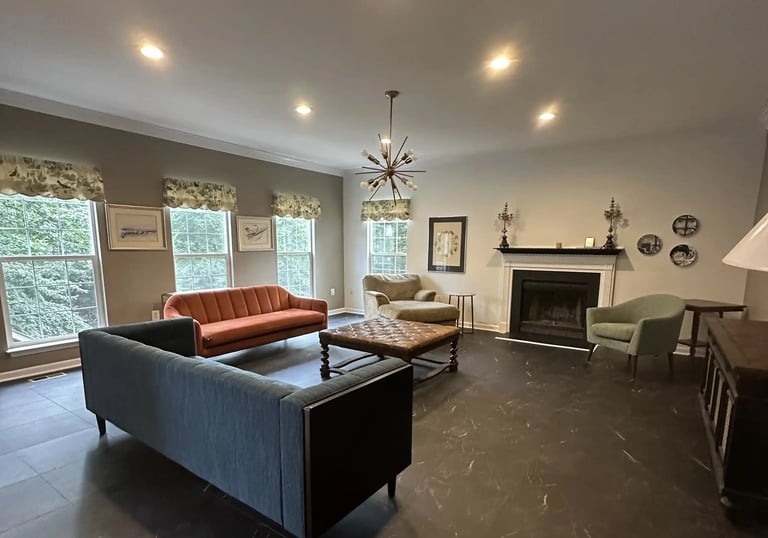 a living room with a couch and a fireplace and vinyl tile.