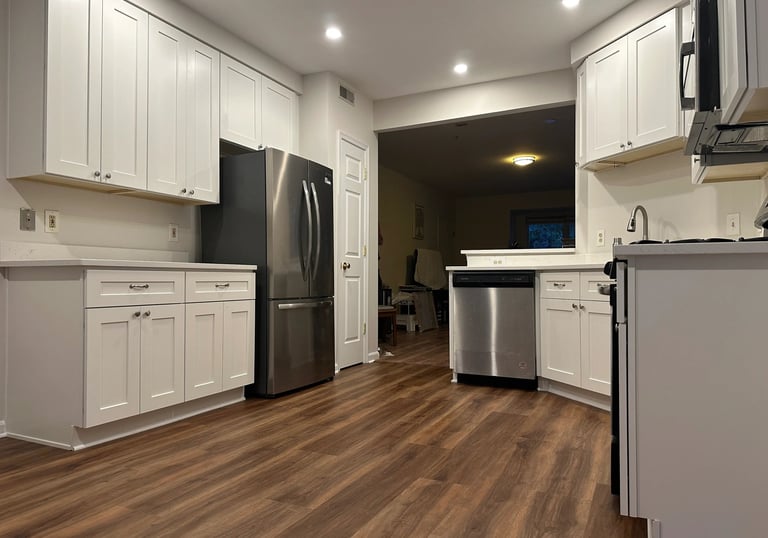 Spacious kitchen remodel with white cabinets, pro stainless steel appliances, & counter space.
