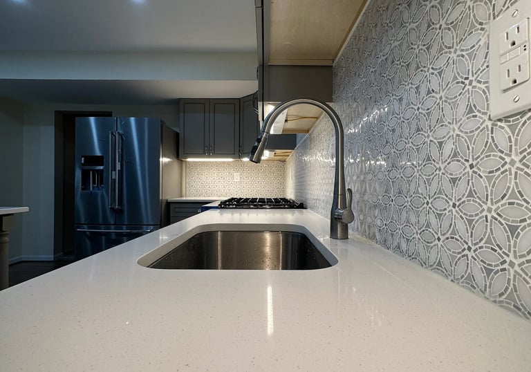 Remodel detail: grey cabinets, white quartz counter, and modern patterned backsplash.