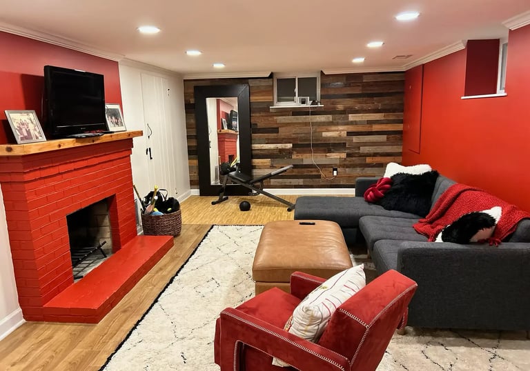 renovated basement with red wall, reclaimed wood accent wall.