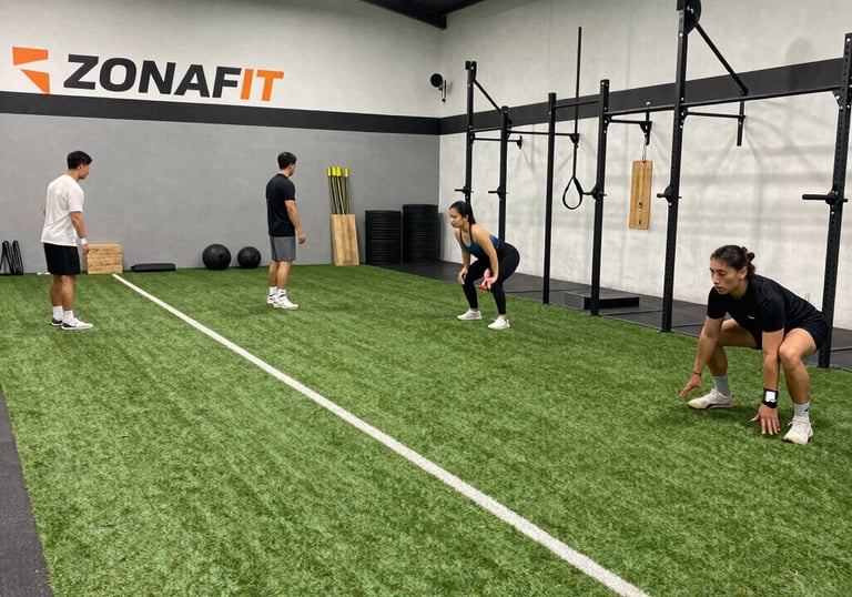 Modern gym area with people using various strength and mobility equipment.