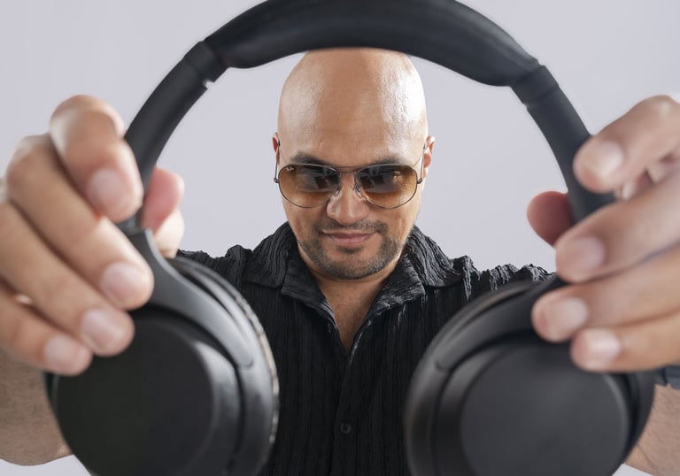 a man in a black shirt and sunglasses holding a pair of headphones