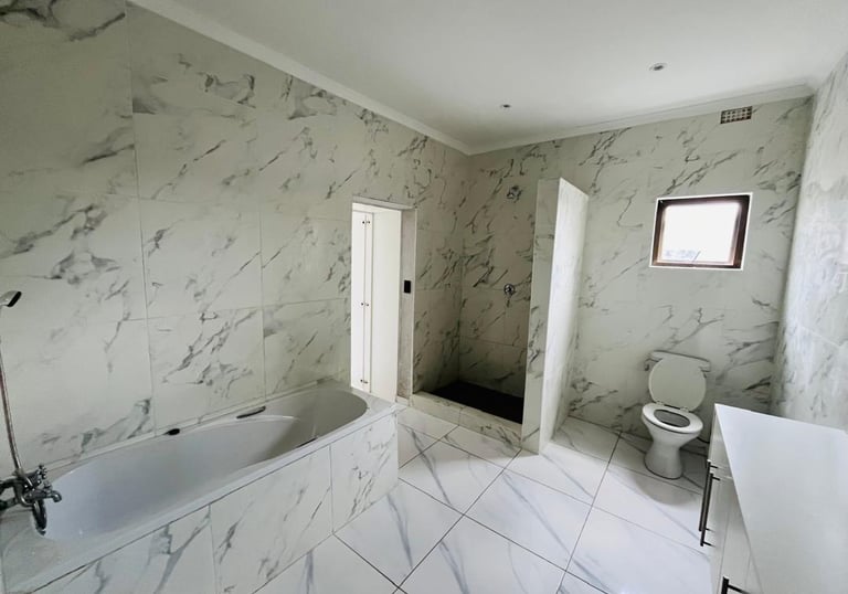 a bathroom with a tub tub and a toilet, House Construction Frans-del Investment CC Construction comp