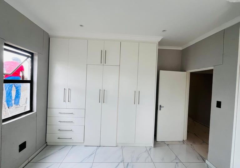 a room with a large white cabinet and a window, House Construction Frans-del Investment CC Construct