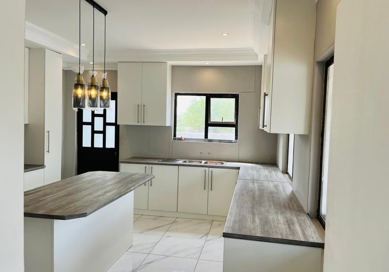 a kitchen with a marble counter top and a wooden counter top, House Construction Frans-del Investmen