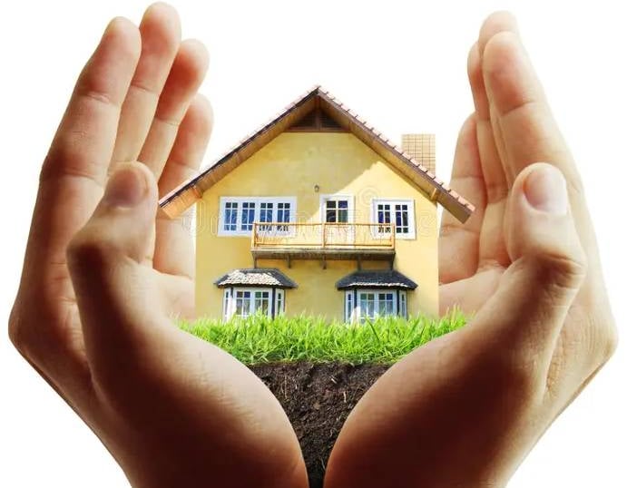 Dos manos formando un cuenco alrededor de una casa en miniatura y césped verde,