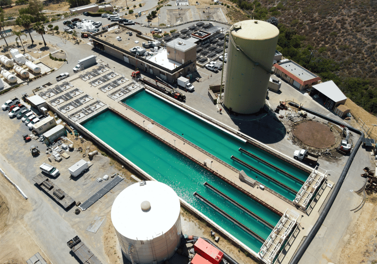 Aerial view; large water treatment or industrial processing facility with treatment ponds, storage tanks, and infrastructure