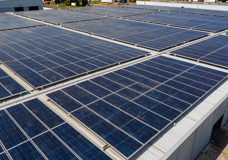 Wide shot of a large industrial warehouse in Brazil with an extensive array of solar panels covering the entire roof surface.