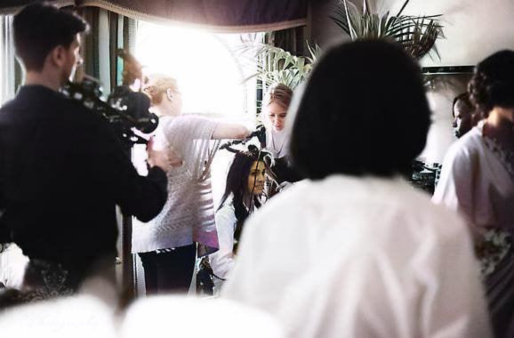 makeup artist working on hair and makeup for a bride