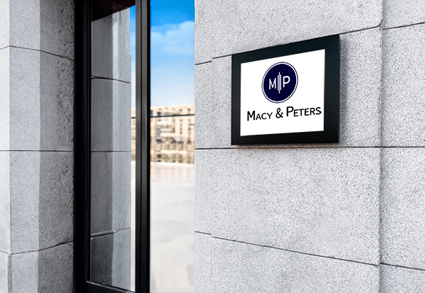 Macy & Peters professional law firm office signage on a modern stone building facade.