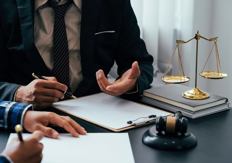 Professional lawyer in a suit providing legal advice with scales of justice and a gavel on the desk.
