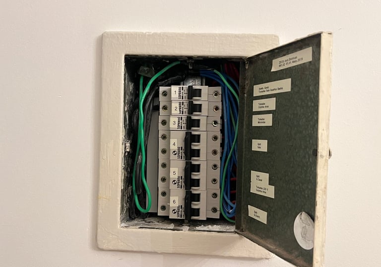 Open electrical breaker panel showing labeled circuit breakers and organized wiring for home safety.