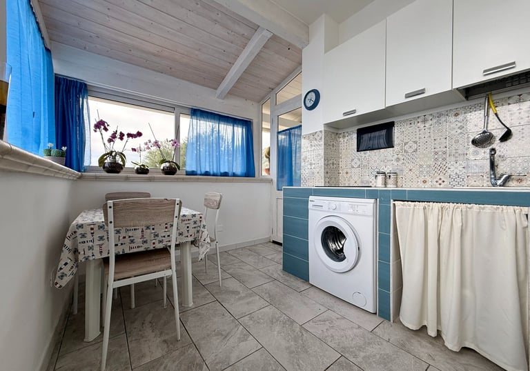 Cucina attrezzata in appartamento vacanze con frigorifero e lavatrice